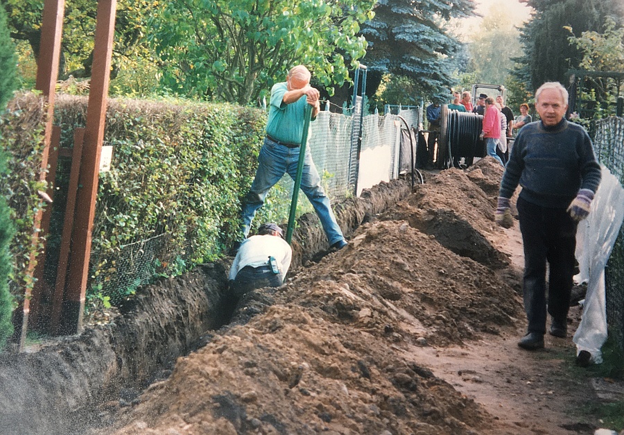 Männer graben einen Kanal für Stromkabel